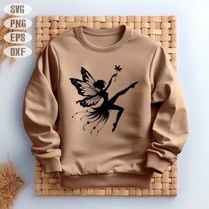 May include: A brown sweatshirt with a black silhouette of a fairy with wings holding a flower.