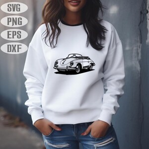 May include: White sweatshirt with a black and white graphic of a vintage convertible car. The car is a classic design, with a low profile and rounded features. The sweatshirt also has the text "SVG, PNG, EPS, DXF" in a white oval shape.