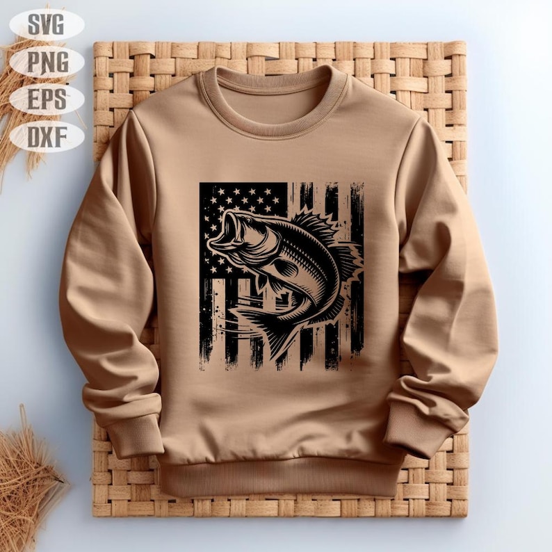 K&ouml;nnte beinhalten: Ein braunes Sweatshirt mit einer schwarzen und wei&szlig;en Grafik eines Fisches, der aus einer notleidenden amerikanischen Flagge springt.