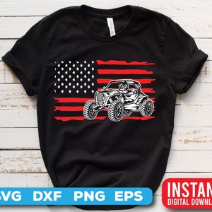 May include: Black t-shirt with a red, white, and blue American flag design and a white silhouette of an off-road vehicle.