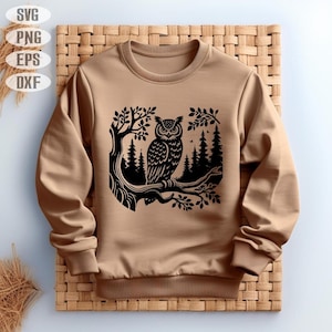 May include: A brown sweatshirt with a black silhouette of an owl perched on a branch in a forest setting.