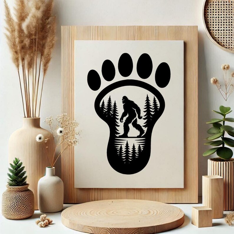 May include: Black and white Bigfoot print. The design features a large footprint with a silhouette of Bigfoot walking through a forest. The print is set in a wooden frame and is a unique piece of wall art.