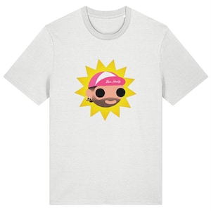 May include: A white t-shirt featuring a cartoon sun with a face, wearing a pink cap with the text "Ben Healy". The sun has yellow rays and a smiling face with black eyes and a beard. The shirt has a crew neck.