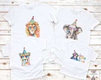 May include: Set of four white t-shirts with colourful animal illustrations wearing party hats and sunglasses. The shirts feature a lion, elephant, cheetah, and monkey. The monkey shirt has the text "born two be wild".