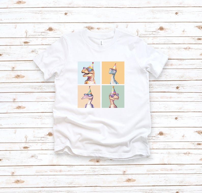 Puede incluir: Camiseta blanca con un gr&aacute;fico de cuatro dinosaurios con sombreros de fiesta y gafas de sol. Los dinosaurios est&aacute;n en un patr&oacute;n de cuadr&iacute;cula con un fondo azul claro, amarillo, verde y verde claro.