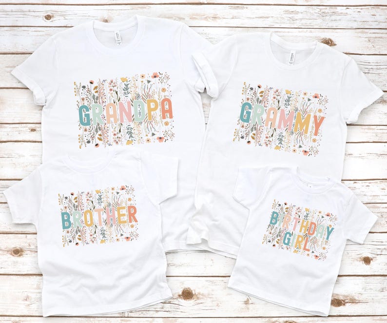May include: Four white t-shirts with floral designs and text. The shirts say "Grandpa", "Grammy", "Brother", and "Birthday Girl".