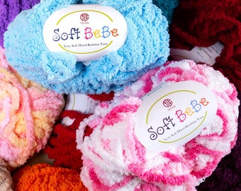 May include: Assortment of colorful yarn skeins in various shades of pink, blue, orange, yellow, and white. The yarn is soft and fluffy, and the skeins are labeled "Soft BeBe Very Soft Hand-Knitting Yarn".