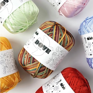Könnte beinhalten: Sortiment an bunten Garnknäueln, darunter hellgrün, rosa, blau, mehrfarbig, gelb und rot. Das Garn ist mit "Dove Club Yarn" gekennzeichnet.