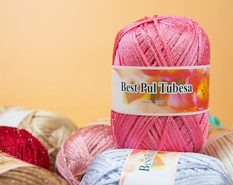 May include: A close-up of a pink yarn ball with silver glitter. The yarn ball has a label that reads "Best Pul Tubesa Hand Knit".