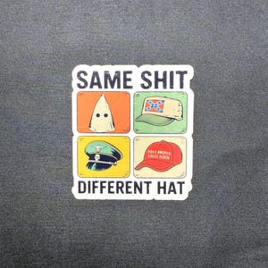 May include: A sticker with the text "SAME SHIT DIFFERENT HAT" above four images of hats. The hats include a white hood, a Confederate flag hat, a military hat, and a red "Make America Great Again" hat.