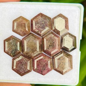 Peut inclure: Dix pierres précieuses facettées hexagonales dans une variété de nuances de rose et de brun avec des accents argentés. Les pierres précieuses sont disposées en nid d'abeille.