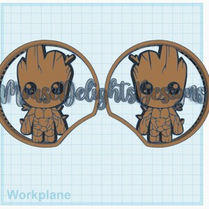 May include: A pair of brown and black 3D printed Mickey Mouse ears featuring a cartoon image of Groot from Guardians of the Galaxy. The ears are designed to look like Groot's head and body, with his signature pot-like head and leafy arms.