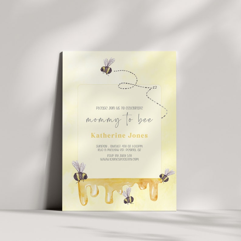 May include: A yellow baby shower invitation with a watercolor illustration of dripping honey and bees. The text reads "Please join us to celebrate mommy to be Katherine Jones, Sunday, August 4th at 1:00pm, 150 N. Meadow Rd, Peoria, AZ, RSVP by July 31st, www.jonesregistry.com"