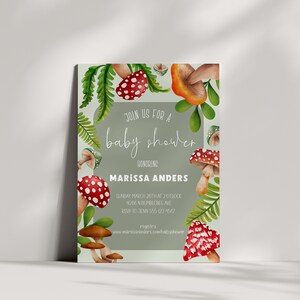 Op de afbeelding: Een uitnodiging voor een babyshower met een groene achtergrond en een rand van rode en oranje paddenstoelen. De tekst luidt "Join us for a baby shower honoring Marissa Anders".