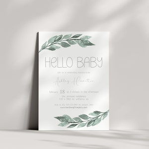 May include: A baby shower invitation featuring a watercolour illustration of green leaves and the text "HELLO BABY". The invitation is for Ashley Hamilton and includes the date, time, and location of the shower. RSVP information is also provided.