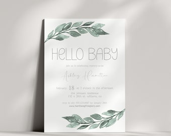 Può includere: Un invito a un baby shower con un'illustrazione ad acquerello di foglie verdi e il testo "HELLO BABY". L'invito è per Ashley Hamilton e include la data, l'ora e il luogo del baby shower. Sono incluse anche le informazioni RSVP.