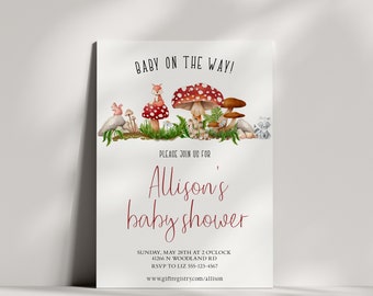 Può includere: Un invito a una festa di benvenuto per il bambino con un tema boschivo. L'invito presenta un fungo rosso e bianco, una volpe, uno scoiattolo e un procione. Il testo sull'invito recita "Baby on the Way!" e "Allison's baby shower". L'invito include anche la data, l'ora, il luogo e le informazioni RSVP.