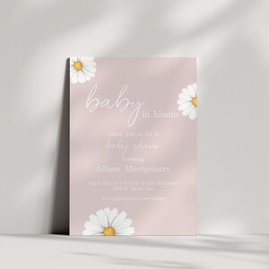 Pu&ograve; includere: Un invito a una festa di baby shower rosa con margherite bianche e il testo "baby in bloom" e "please join us for a baby shower honoring Allison Montgomery April 12th at 1 o'clock in the afternoon 2121 N Daisy Ave www.giftregistry.com/allsion"