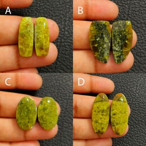 Puede incluir: Cuatro pares de piedras preciosas verdes y amarillas, cada una con un patrón y forma únicos. Las piedras preciosas se sostienen en una mano, mostrando sus variaciones de color y texturas. Las piedras tienen forma ovalada y de lágrima.