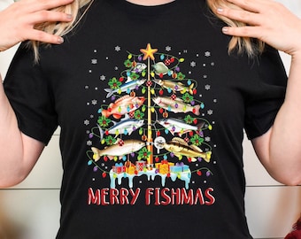 Può includere: Maglietta nera con un design di albero di Natale fatto di pesci e il testo "Merry Fishmas".