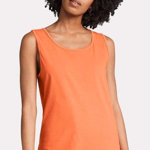 May include: A solid orange sleeveless tank top with a round neckline. The garment features a simple, clean design with wide shoulder straps and a straight hemline, constructed from a plain fabric that provides a consistent, vibrant color throughout.