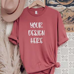 May include: A dusty rose colored t-shirt with the text "YOUR DESIGN HERE" printed in white on the front.