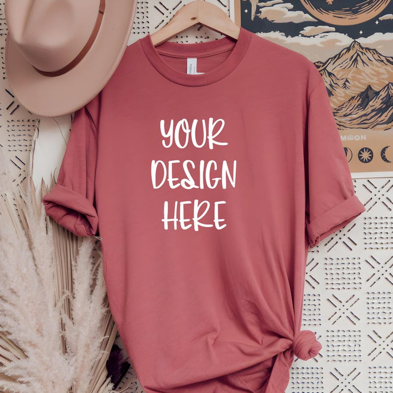 May include: A dusty rose colored t-shirt with the text "YOUR DESIGN HERE" printed in white on the front.