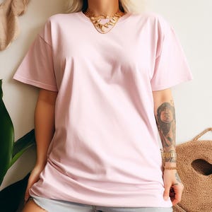 May include: A pale pink oversized t-shirt with short sleeves. The t-shirt is made of a soft, comfortable fabric.