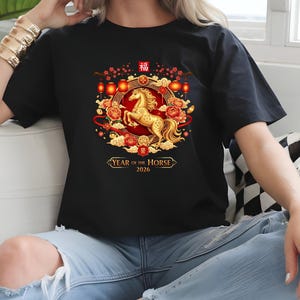 May include: Black t-shirt featuring a golden horse design within a circular frame with red and gold accents. The design includes Chinese characters and the text "YEAR OF THE HORSE 2026".