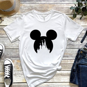 May include: White t-shirt with a black silhouette of Mickey Mouse's head with the silhouette of Cinderella's castle inside the ears.
