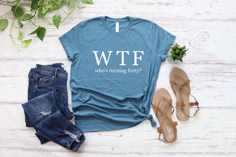 K&ouml;nnte beinhalten: Ein blaues T-Shirt mit dem Aufdruck "WTF who's turning forty?" in wei&szlig;.