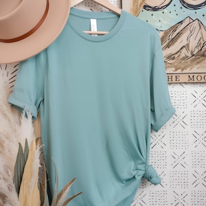 May include: A light blue t-shirt with a crew neck and short sleeves. The shirt is made of a soft, comfortable material.