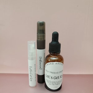 May include: Three Wayward Arrow products: a small spray bottle labelled "Let's Get Icy", a brown eyeliner pencil labelled "Driftwood", and a brown glass bottle with a dropper, also labelled "Let's Get Icy".