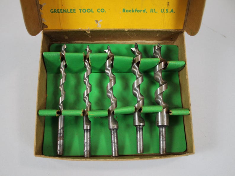Op de afbeelding: Een set van zes boortjes in een kartonnen doos met een groene binnenkant. De doos is gelabeld "GREENLEE TOOL CO. Rockford, Ill., U.S.A."