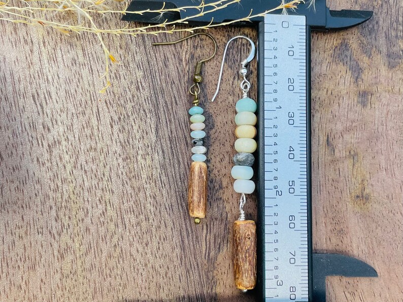 Peut inclure: Boucles d'oreilles faites &agrave; la main avec des perles de pierres naturelles bleues, cr&egrave;me et grises, et un &eacute;l&eacute;ment en bois. Les boucles d'oreilles mesurent environ 7.6 cm de long, de style boh&egrave;me rustique.