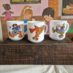 An Arcopal opaline white milky glass mug or tankard from France, 70s and 80s, several models with a colorful clown theme