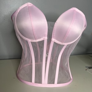 May include: A pink satin and mesh corset with boning and a sweetheart neckline.