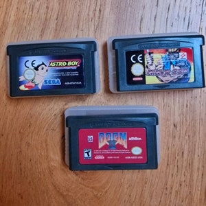 Pakiet trzech gier akcji - Nintendo Game Boy Advance. Karty GBA z etui: Astro Boy, Doom 2 i Ninja Cop / Ninja Five-0