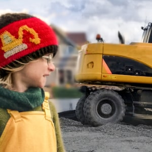 May include: A young person wearing a red and brown knitted hat with a yellow excavator design. The hat is pulled down over their forehead. The person is standing in front of a yellow excavator.