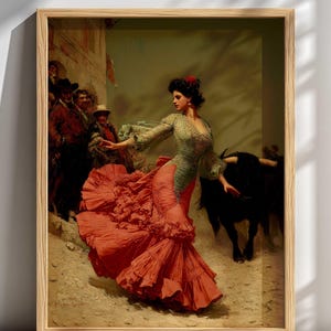 May include: Framed artwork depicting a woman in a red dress and green top, dancing near a black bull. A crowd of people watches from the background. The artwork is in a wooden frame, with a light background.