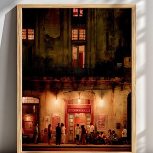 May include: A framed art print depicts a nighttime scene of a building with a red door and windows. People are gathered outside, illuminated by warm lighting. The artwork has a vintage, painterly style with a wooden frame.
