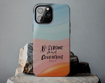 May include: A phone case with a watercolor-style background in shades of blue, pink, and orange. The case features the text "Be Strong and Courageous" with the scripture reference "Joshua 1:9".
