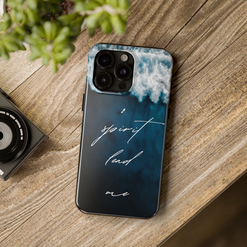 May include: A blue and white phone case with a watercolor-style design of clouds and waves. The text "spirit lead me" is written in white cursive on the case.