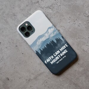 May include: A white phone case with a blue and white mountain scene and the text "FAITH CAN MOVE MOUNTAINS MATTHEW 17:20".