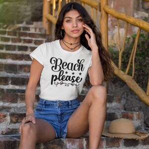 May include: A white t-shirt with the text "Beach Please" in black lettering with three stars above the word "Please". The shirt is being worn by a person sitting on a brick staircase.
