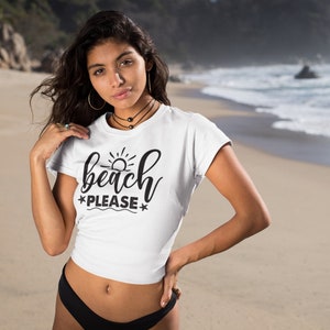May include: White crop top with a black graphic that says "beach please" with a sun and waves design.