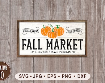 Könnte beinhalten: Ein weißes Holzschild mit braunem Rahmen, das ein Herbstmarkt-Thema zeigt. Das Schild trägt oben den Text "Locally Grown" und "Pure Organic", mit drei orangefarbenen Kürbissen in der Mitte. Der Text "Fall Market" ist in großen schwarzen Buchstaben, und der Text "Hayrides - Corn Maze - Pumpkin Pie" ist in kleineren schwarzen Buchstaben darunter.