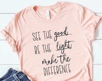 Puede incluir: Una camiseta rosa con el texto "SEE THE good BE THE light make the DIFFERENCE" en letras negras.