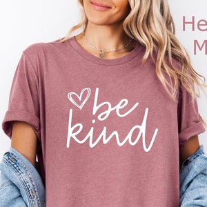 May include: A heather mauve t-shirt with a white heart and the text "be kind" printed on the front.