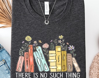 May include: A dark grey heather t-shirt featuring a graphic of colorful books with flowers growing from the tops. The text "THERE IS NO SUCH THING as too many books" is printed in white below the books. A silver sunburst pendant necklace is included.
